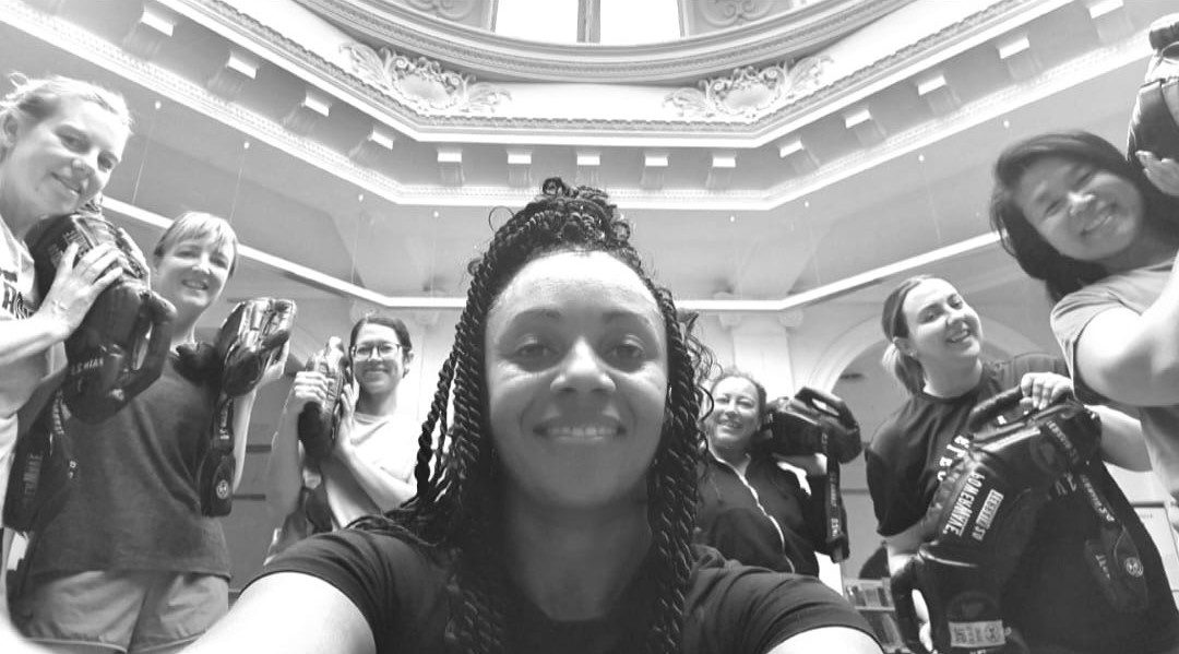Group selfie of diverse people celebrating together in ornate government building rotunda with decorative ceiling