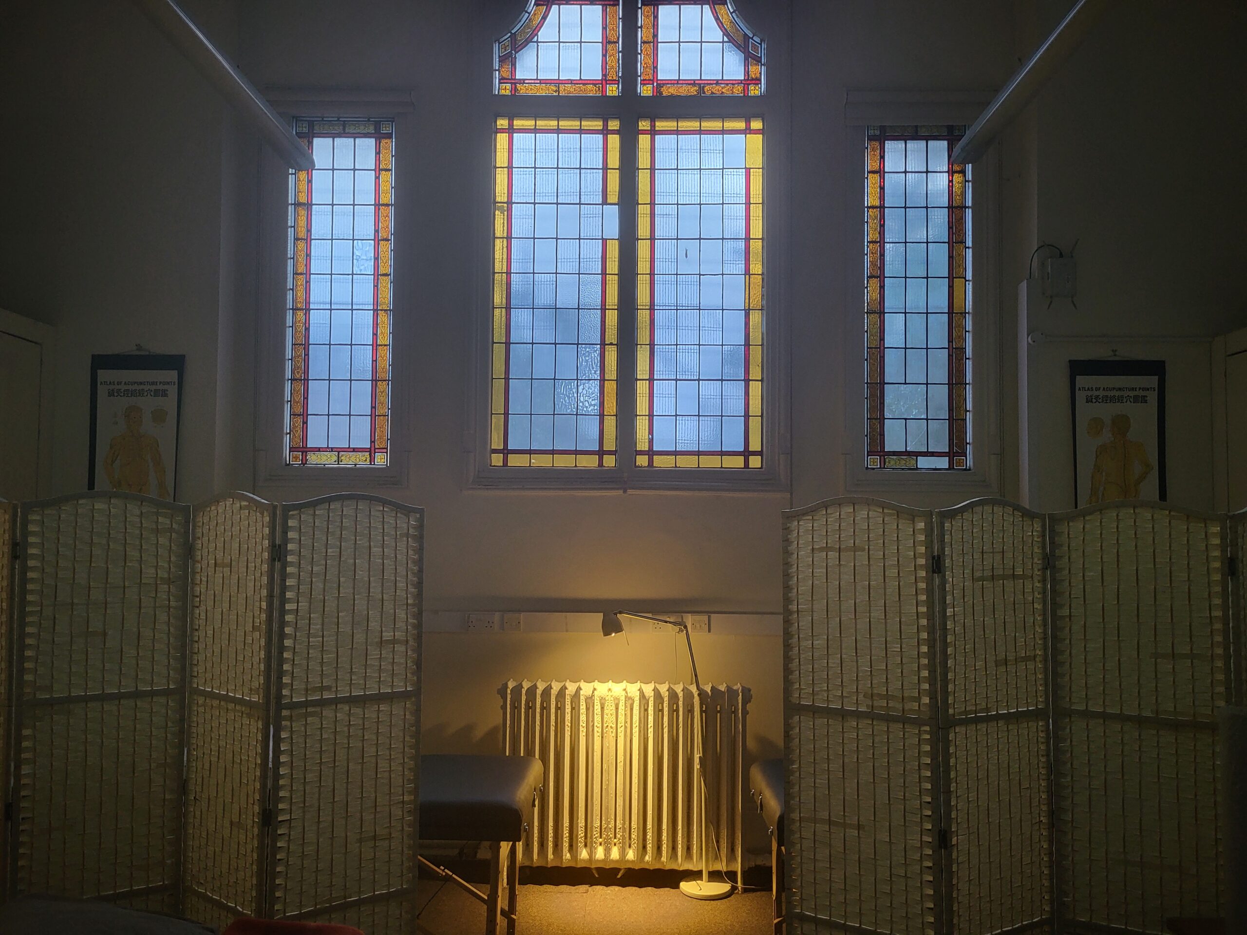 Historic library interior with ornate stained glass windows, wooden card catalogs, and warm lighting at dusk