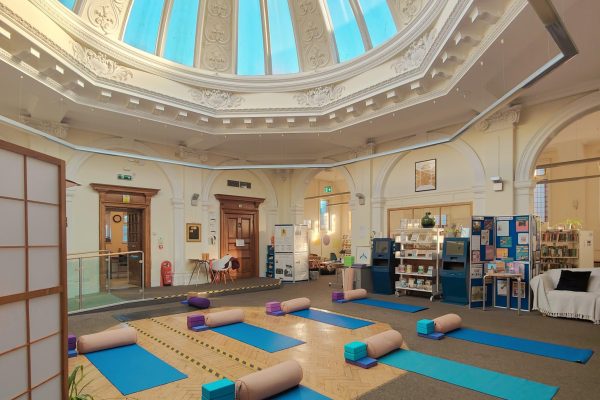 Yoga mats and props arranged in ornate library rotunda with decorative domed ceiling and classical architecture